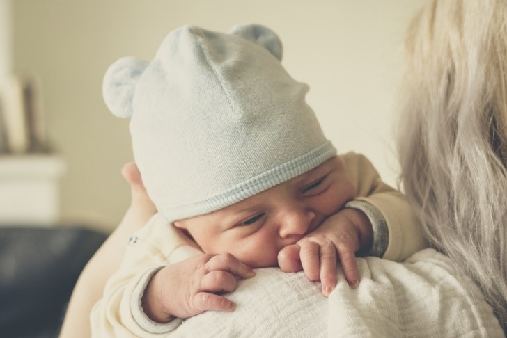 Volunteer cuddling newborn baby in the hospital